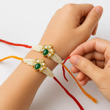 Handcrafted Pearl Rakhi with Green Kundan Floral Center (Set of 2)